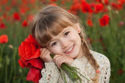 Niña-feliz-con-ramo-de-flores-rojas