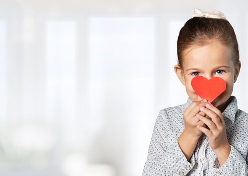 Une jeune fille avec un coeur en papier.