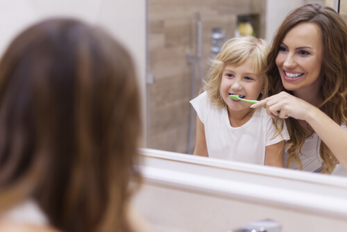 Une mère qui brosse les dents de sa fille. 