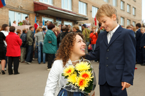 Een moeder die haar zoon wegstuurt tijdens de eerste schooldagen.