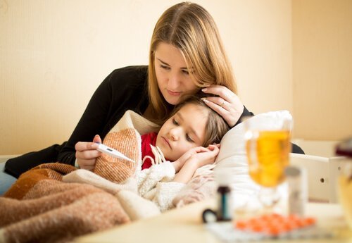 Niña con fiebre y madre preguntándose si es verdad que los niños crecen cuando tienen fiebre.