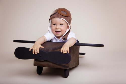 Un jeune enfant qui joue avec un avion en bois.