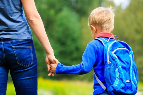 Une mère qui donne la main à son enfant.