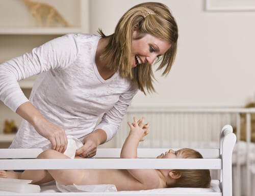 Une mère qui change son bébé.