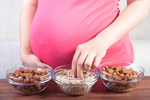 A pregnant woman eating nuts and seeds.