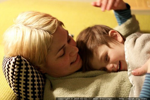 A young boy lying on his mother's chest.