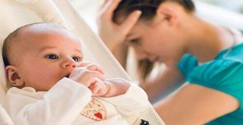 A woman feeling stressed about motherhood.
