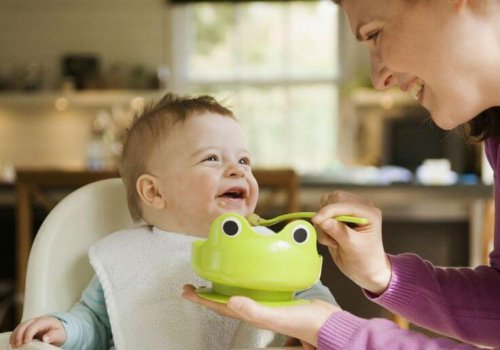 Une maman qui donne de la purée à son enfant.