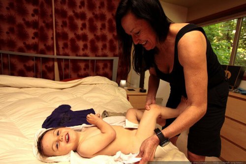 Une maman qui habille son enfant.