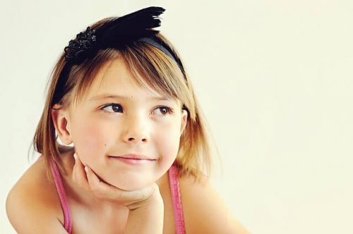 A young girl smiling thoughtfully.