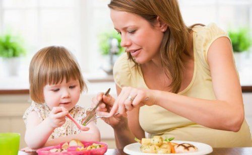 Une maman qui mange avec sa fille.