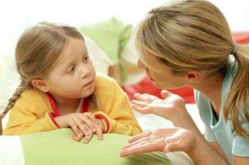 En mamma pratar med en ung flicka.