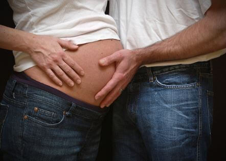 Padre tocando el vientre embarazado de la mamá