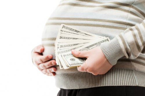 Pregnant woman holding dollar currency cash