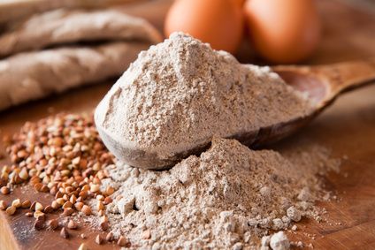 Buchwheat flour in a wooden measuring spoon