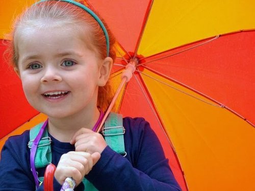 Niña con u paraguas llevando a cabo programas de educación emocional.