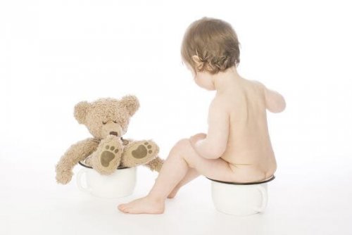 toddler and teddy bear sitting on potties