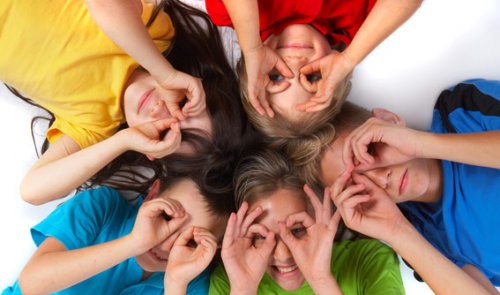 5 enfants allongés qui imitent des lunettes sur leurs yeux.