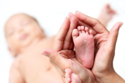 Clouse-up of newborn baby's foot in mammy's hands