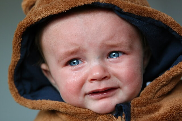 bebé con capucha llorando