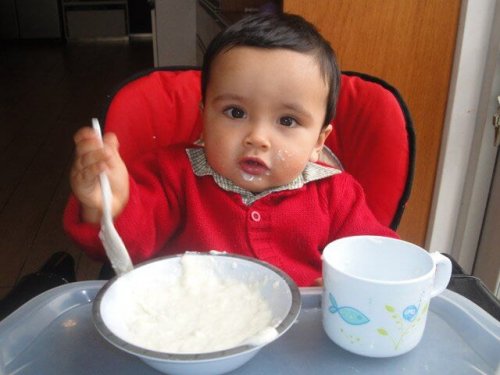 Un enfant qui mange dans sa chaise.