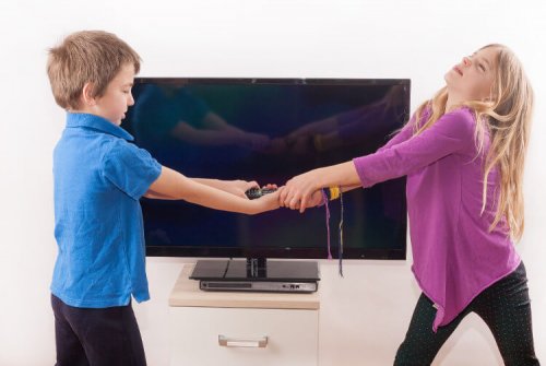 Two children fighting over a remote control.