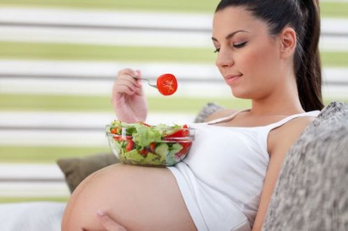 Beautiful healthy young pregnancy eating vegetable salad