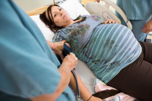 enfermera toma la tensión a mujer embarazada