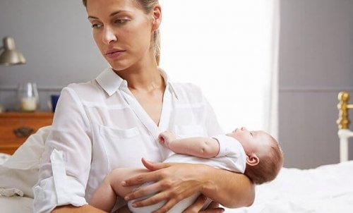 A sad mom holding her baby.