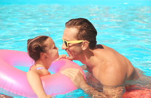Un père et sa fille dans une piscine.