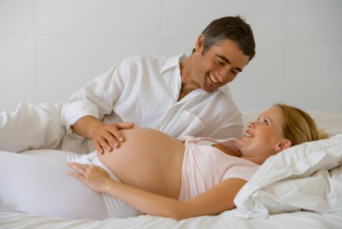 Man feeling pregnant woman's belly