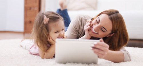 Madre con su hija explicándole el buen acceso a internet con una tablet.