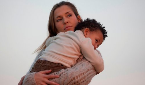 Une maman avec son fils adoptif dans les bras. 