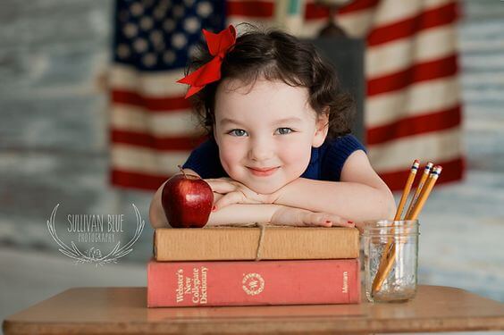 Petite fille avec des livres et des crayons