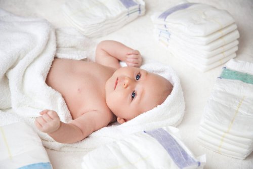 Un bébé nu dans une serviette.