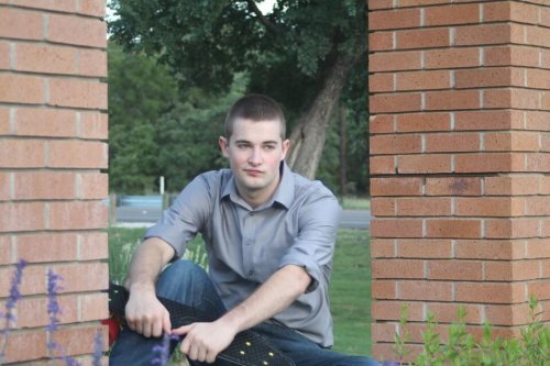 Un adolescent assis dehors.