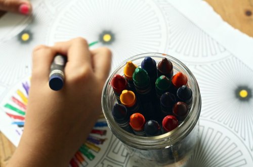Criança pintando com giz de cera.