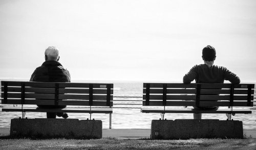 Deux hommes assis sur deux bancs différents.