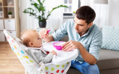 Padre dando de comer a su bebé para que tenga una excelente nutrición infantil.