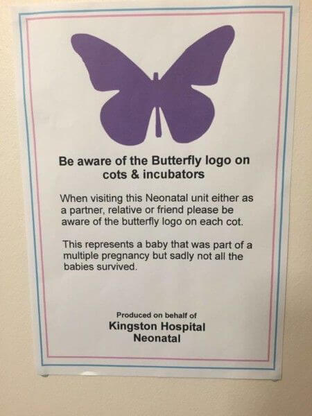 A sign with a purple butterfly that reads: Be aware of the butterfly lovo on cots and incubators. When visiting this neonatal unit, either as a partner, relative, or friend, please be aware of the butterfly logo on each cot. This represents a baby that was part of a multiple pregnancy but, sadly, not all the babies survived. Produces on behalf of Kingston Hospital Neonatal.