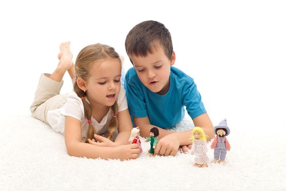 Deux enfants qui jouent avec des figurines. 