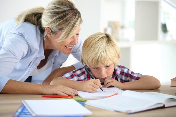 Une mère encourageant son enfant devant ses cahiers de classe 