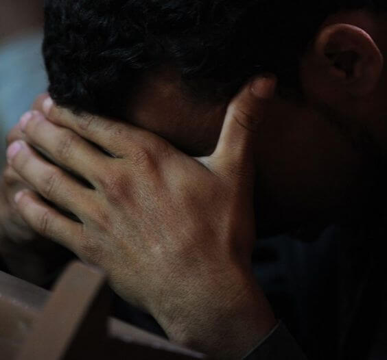 Un jeune qui se cache le visage.