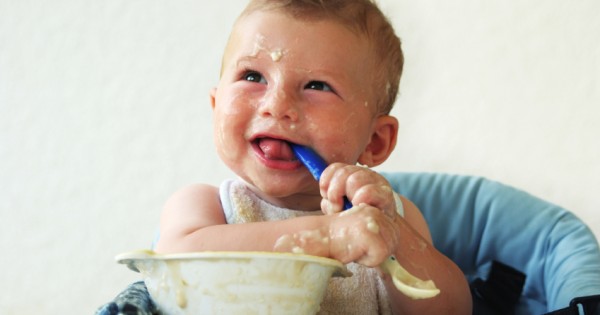 A baby covered in baby food.