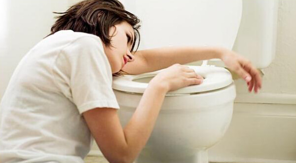 Femme prise de nausées au-dessus des toilettes