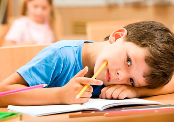 Un enfant couché sur son cahier.