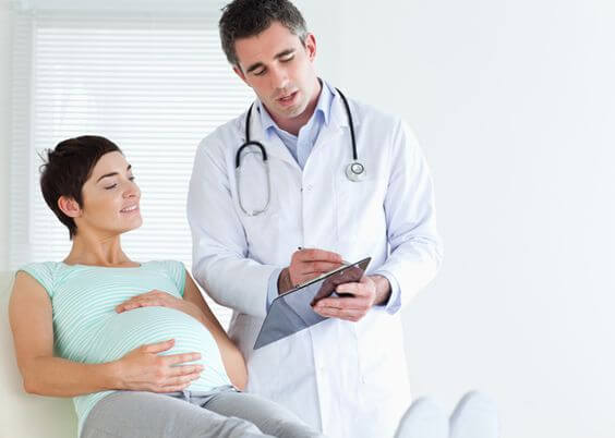 Femme enceinte avec un docteur, qui permet de répondre aux questions sur la grossesse que l'on peut avoir