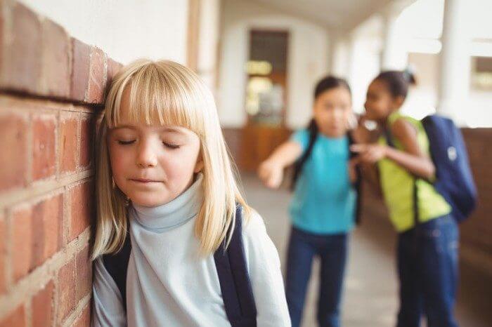 Petite fille moquée par deux camarades à l'école