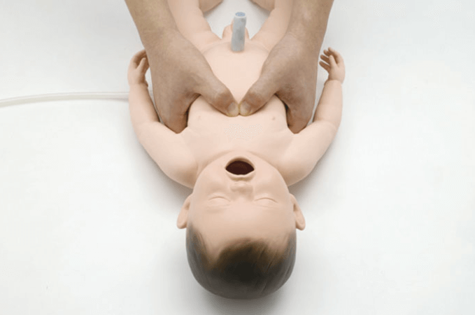 Massage cardiaque d'un bébé mannequin.