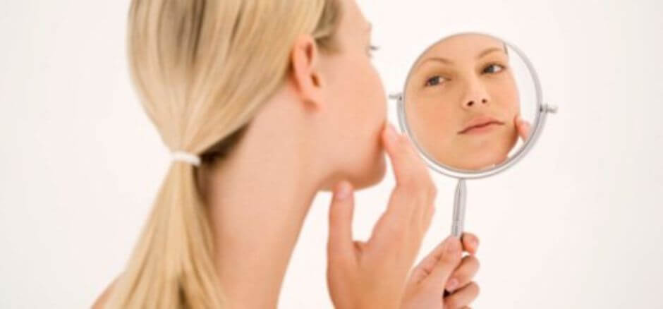 Une femme qui se regarde dans un miroir. 